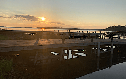 soluppgång: spegling gömmer sig under bryggan+